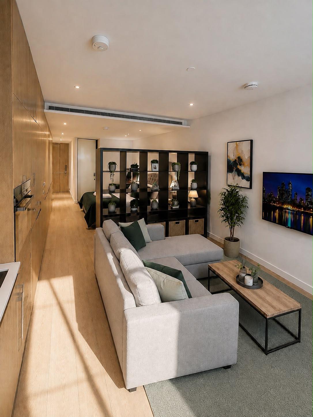 Wide view of the living area with wall-mounted smart TV and shelving divider