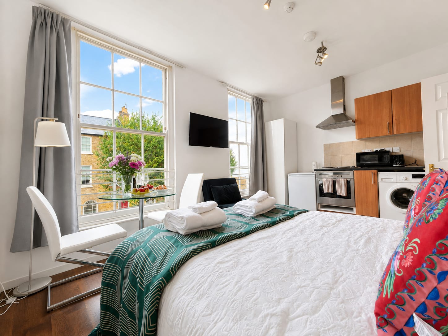 Wide view of the studio with bed, bay window and fitted kitchen