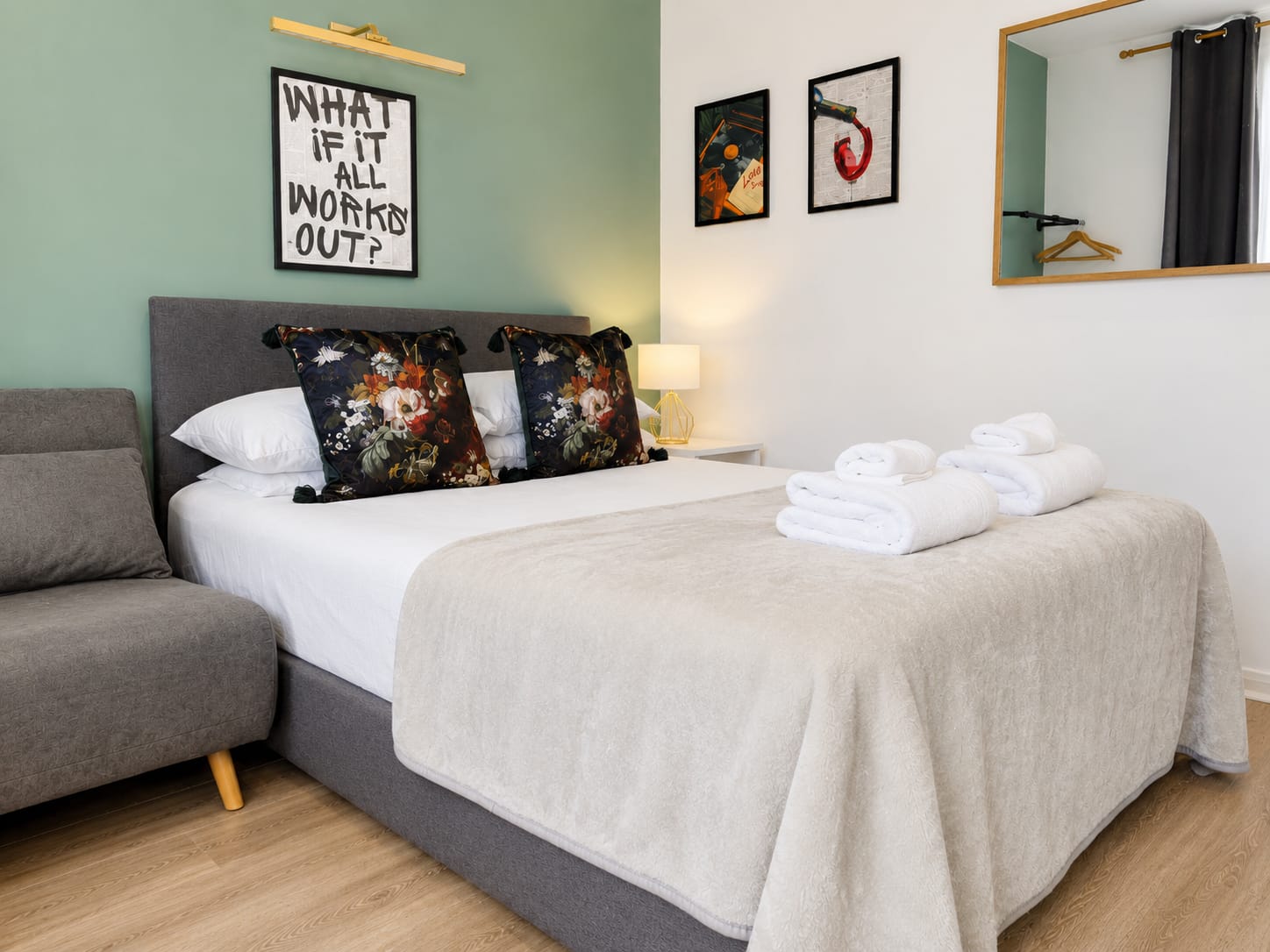 Double bed with floral cushions and soft towels at The Islington Retreat