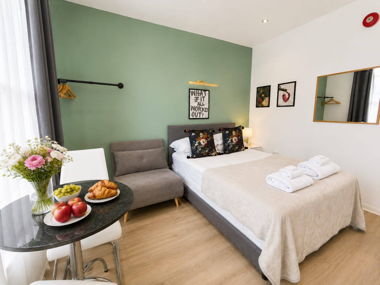 Wide view of the studio with bed, sofa and dining area
