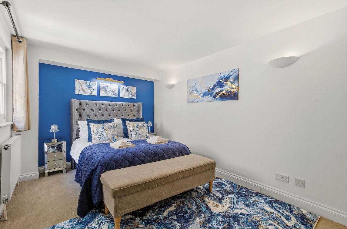 Bedroom with double bed, bedside tables and marble-effect artwork